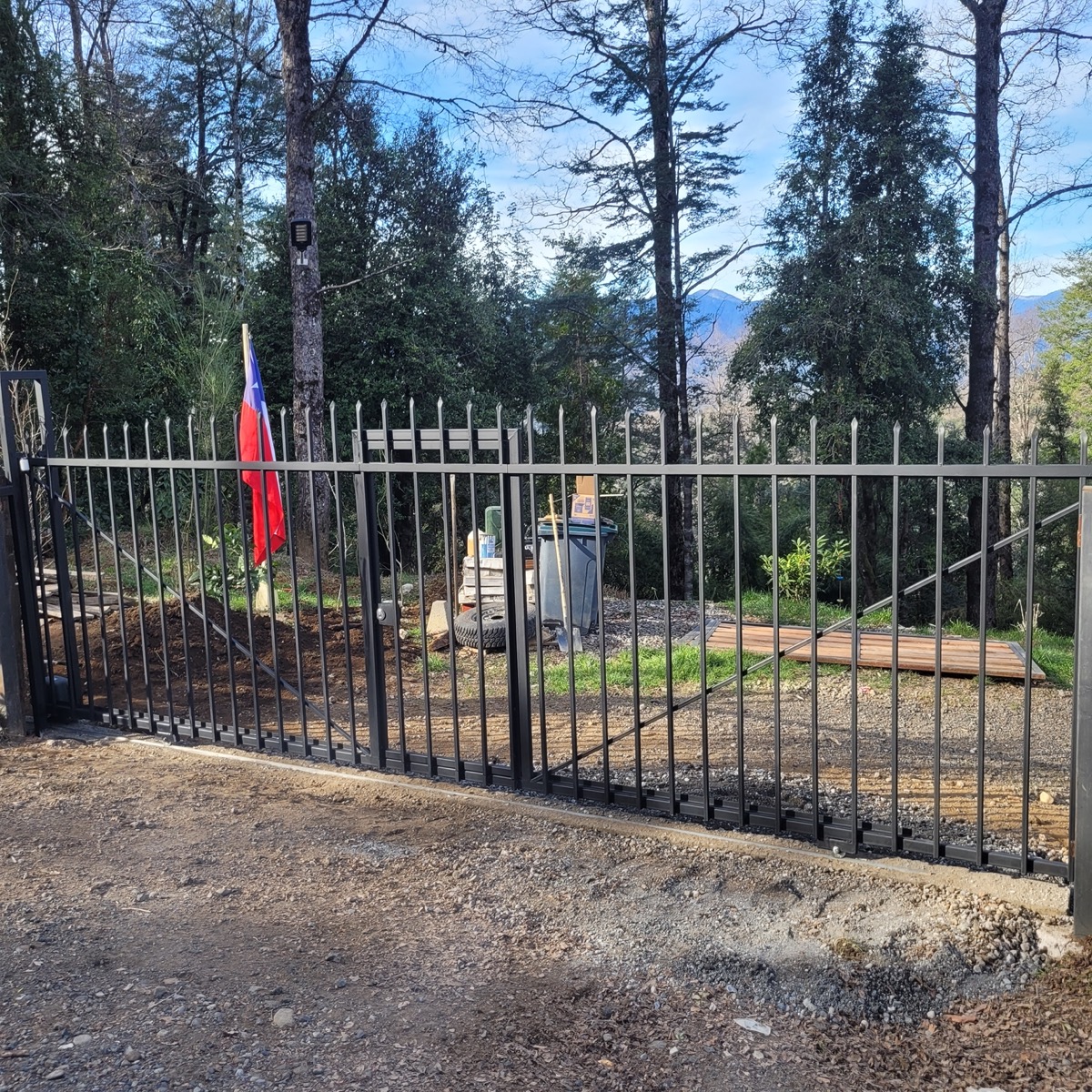 Portón de fierro con puerta peatonal en Los Nevados, sector de Pucón